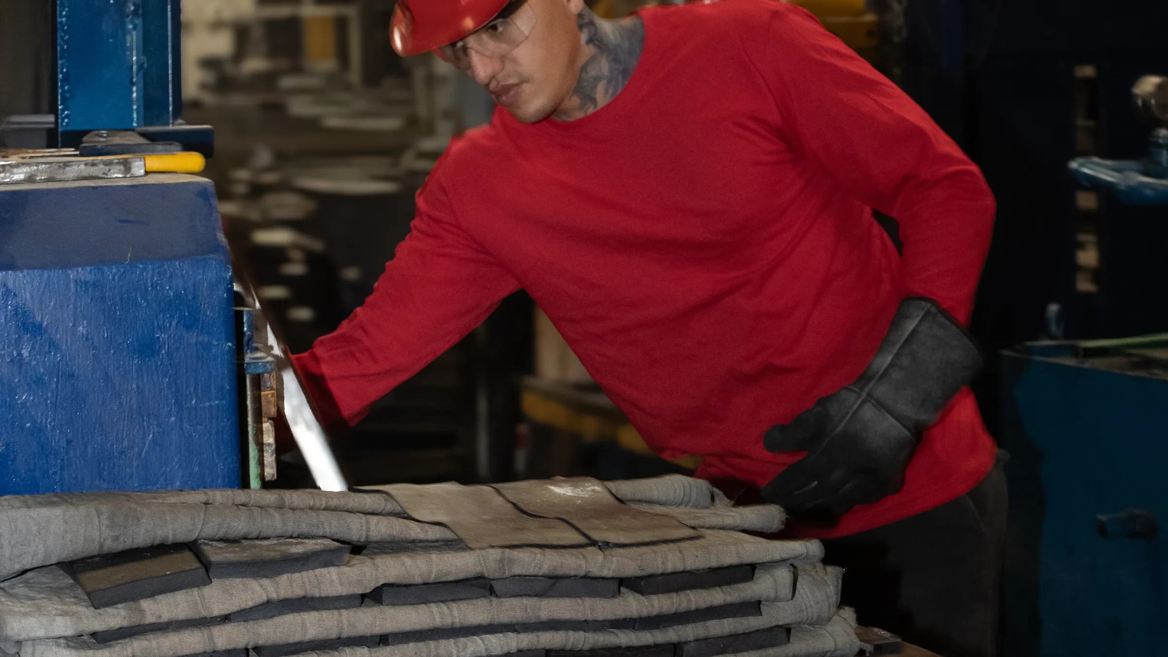 Operario preparando placas de hule para prensado